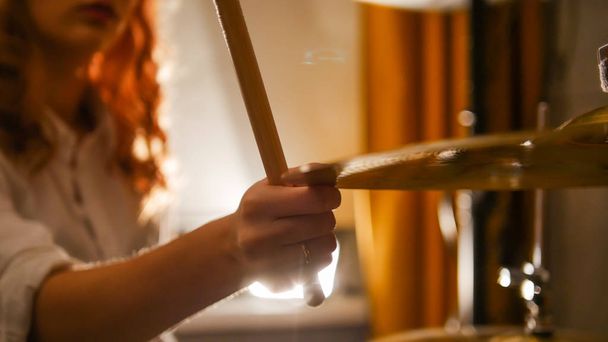 Repetition. Redhead girl drummer holds the hi-hat. Close up - Foto, imagen