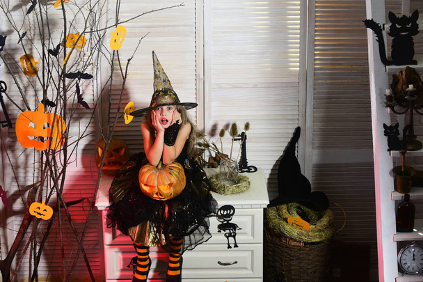 Kleine heks met Halloween decor. Kid in heks hoed - Foto, afbeelding