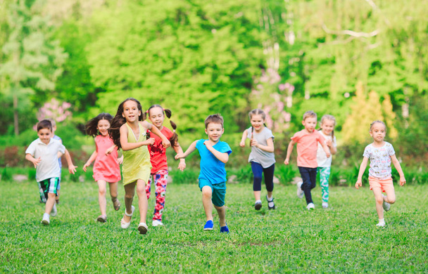 Many different kids, boys and girls running in the park on sunny summer day in casual clothes - Foto, Imagem