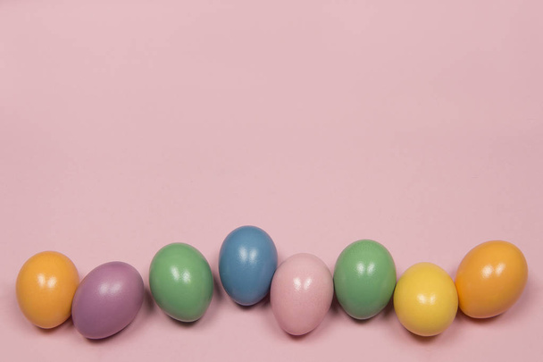 Pastel colored easter eggs on a pink background with copy space - Photo, Image