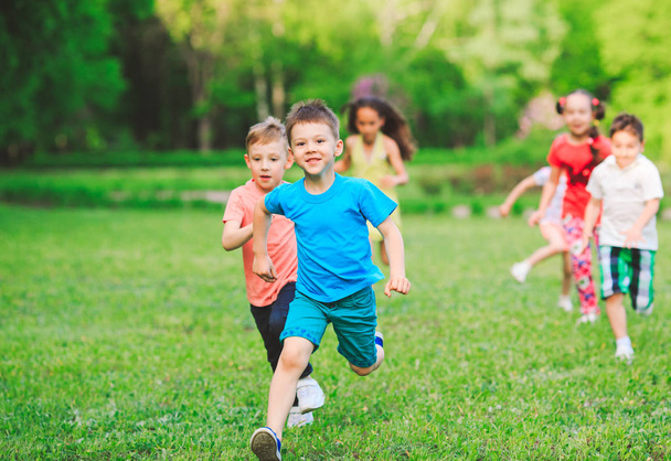 Many different kids, boys and girls running in the park on sunny summer day in casual clothes - Foto, immagini