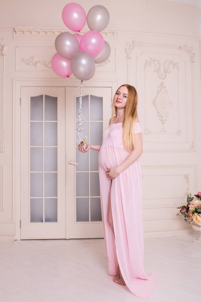 Happy pregnant woman with pink and grey air balloons in her hands. Motherhood, pregnancy and expectation concept - Φωτογραφία, εικόνα