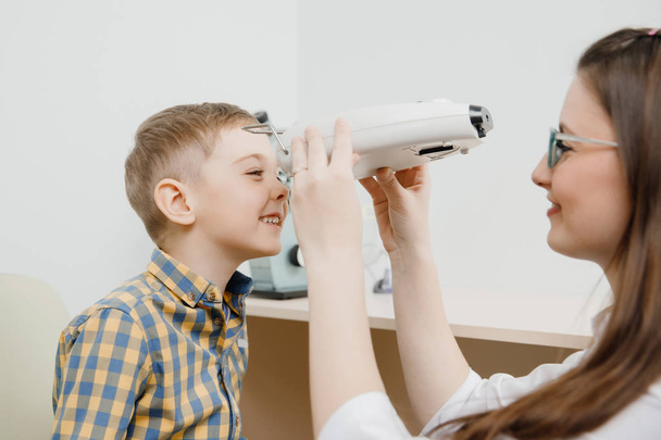 Child reception doctor ophthalmologist selects glasses of lens, check eye sight. - Foto, Imagen