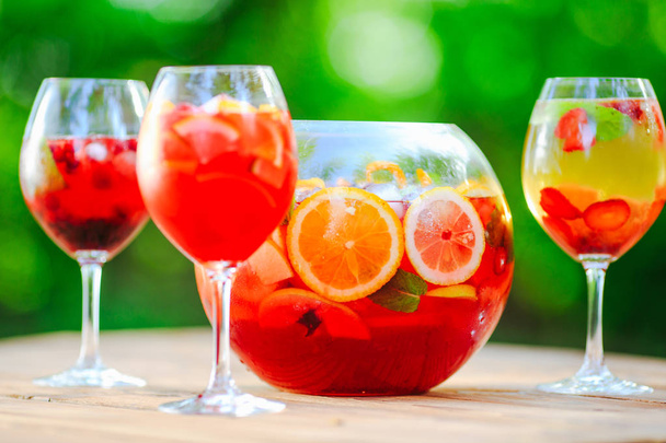 Summer cocktail. Fruit cocktail on green background. Citrus fruits, berries, strawberries, blueberries, mint, ice - Valokuva, kuva
