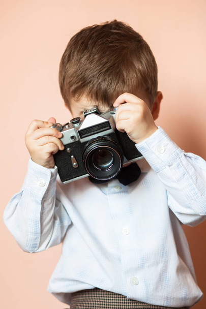 Küçük çocuk yaşlı retro kamera ile. Genç fotoğrafçı. Çocuk eski bir kamera ile - Fotoğraf, Görsel