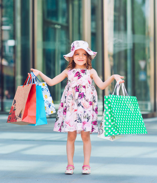 Menina bonito em compras. Retrato de uma criança com sacos de compras. Compras. menina
. - Foto, Imagem