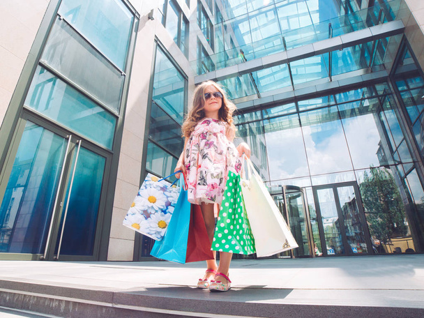 Cute little girl on shopping. Portrait of a kid with shopping bags. Shopping. girl. - Fotó, kép