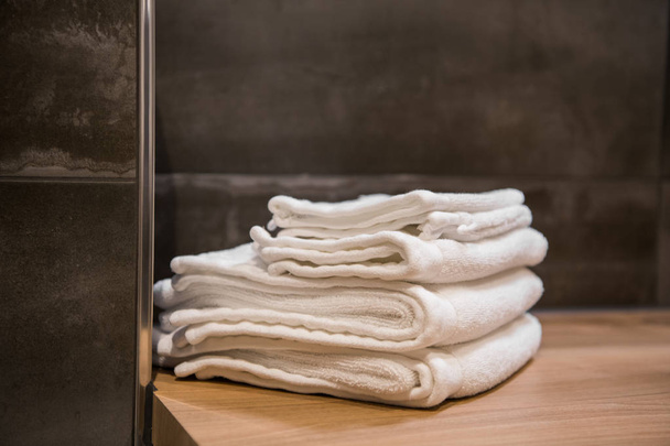 accatastati asciugamani bianchi spa sul tavolo di legno al bagno moderno
 - Foto, immagini