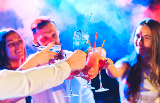 Друзья с коктейлями пьют на вечеринке
. - Фото, изображение