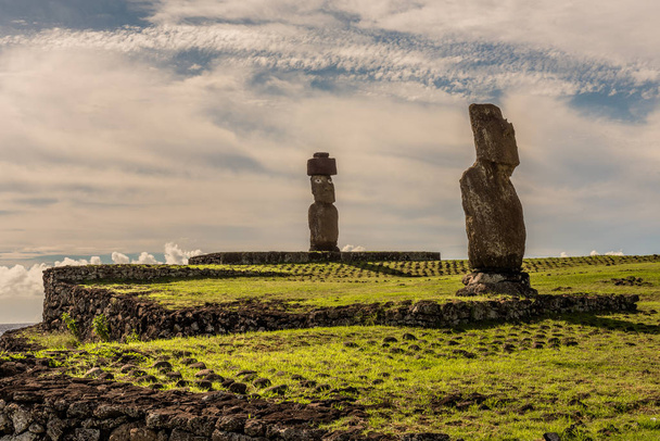 Две статуи Моаи на пьедесталах рядом с пляжем острова Пасхи лицом к острову
. - Фото, изображение