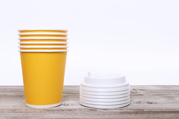 Stack of yellow disposable paper cups and covers. - Φωτογραφία, εικόνα