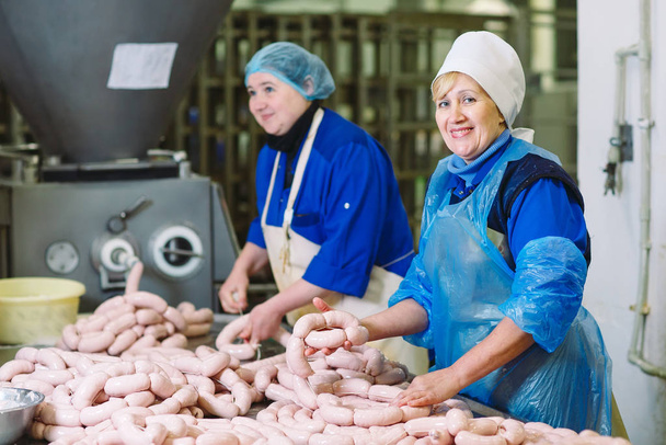 Butchers processing sausages at meat factory. - Foto, Imagem