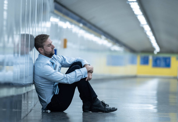 Young jobless business man suffering depression sitting on ground street underground leaning on wall alone looking desperate in Emotional pain Mental health Unemployment and Human emotions concept. - Fotoğraf, Görsel