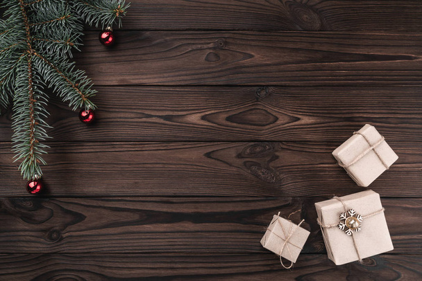 Geschenkdozen over donkere houten achtergrond. Bovenaanzicht. Fir tree met kerstballen, ruimte voor tekst. - Foto, afbeelding