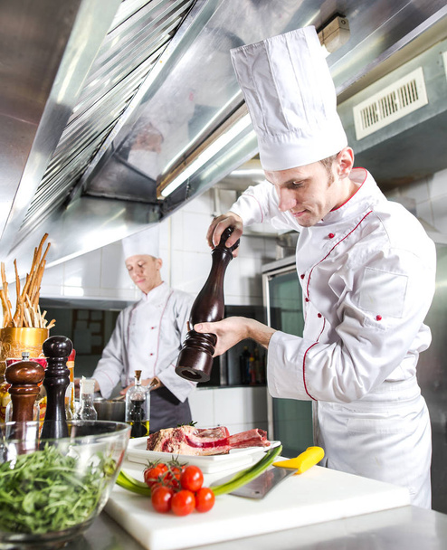 The chef prepares a dish in the kitchen of restoran. - Fotografie, Obrázek