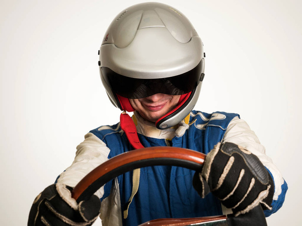 Race car driver in the helmet while driving. On a white background - Foto, afbeelding