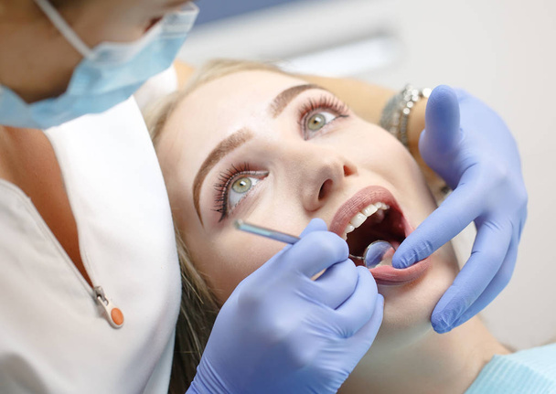 female dentist checking patient girl teeth - Fotoğraf, Görsel