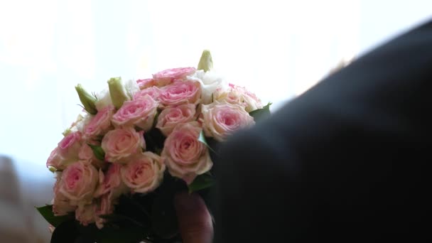 μπουκέτο με πολύχρωμα τριαντάφυλλα στα χέρια ενός ανθρώπου. - Πλάνα, βίντεο