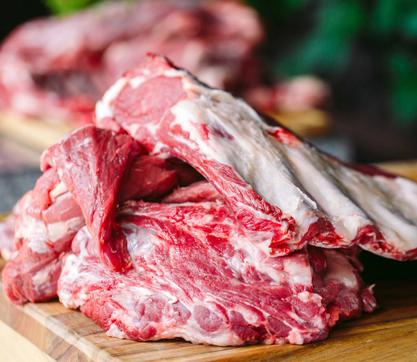 pieces of raw beef on wooden chopping board - Φωτογραφία, εικόνα