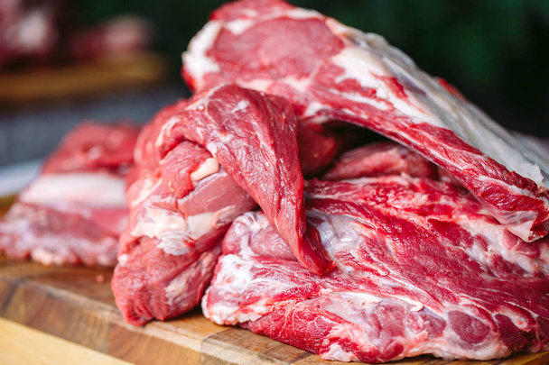 pieces of raw beef on wooden chopping board - Фото, зображення