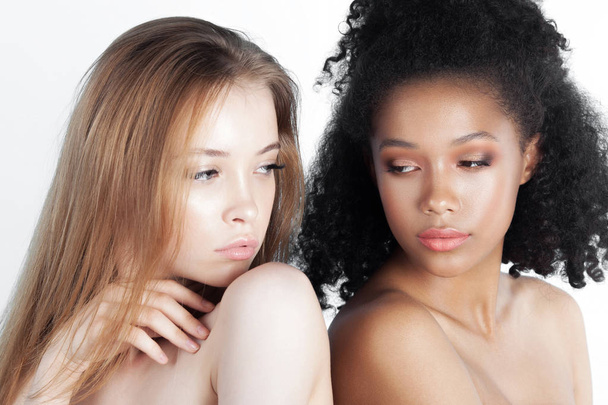Caucasian and african teen girls close-up. Skin care and makeup. Mixed race beauty portrait - Foto, afbeelding