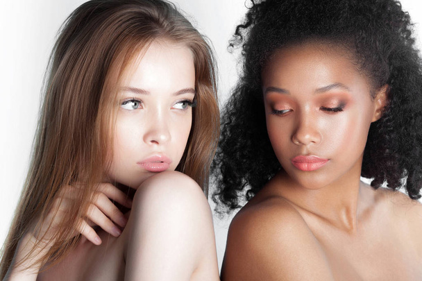 Caucasian and african teen girls close-up. Skin care and makeup. Mixed race beauty portrait - Фото, изображение