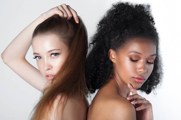 Caucasian and african teen girls close-up. Skin care and makeup. Mixed race beauty portrait - Фото, зображення