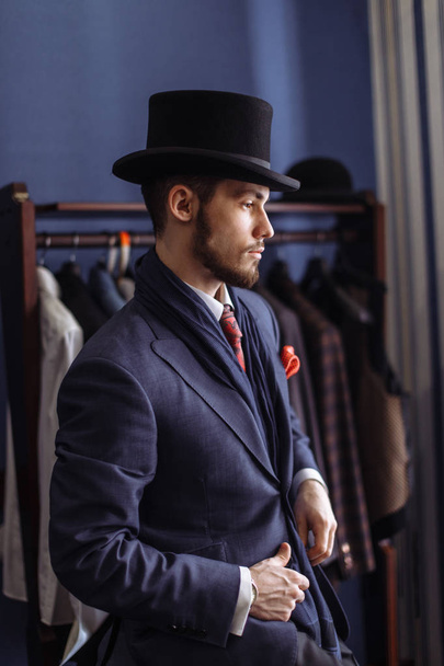 Portrait of attractive man in dark coat and trendy suit indoors tailors - Φωτογραφία, εικόνα