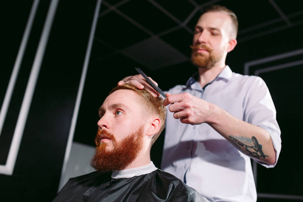 Confident man visiting hairstylist in barber shop. - Foto, Bild