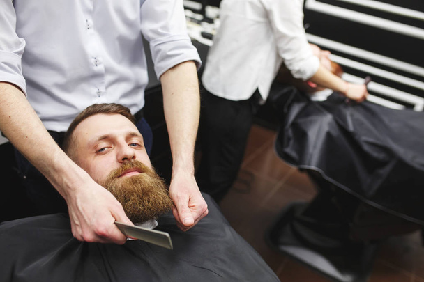 Confident mans visiting hairstylists in barber shop. - 写真・画像