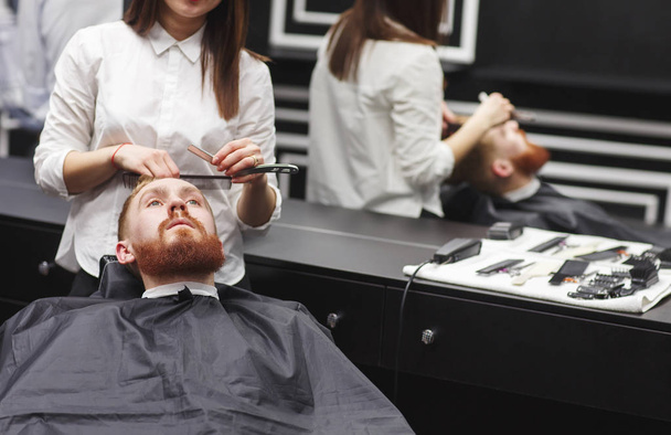 Confident man visiting hairstylist in barber shop. - Foto, Imagen