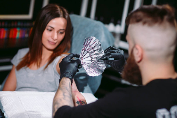 Professional tattooist makes the tattoo on a girl. - Fotoğraf, Görsel