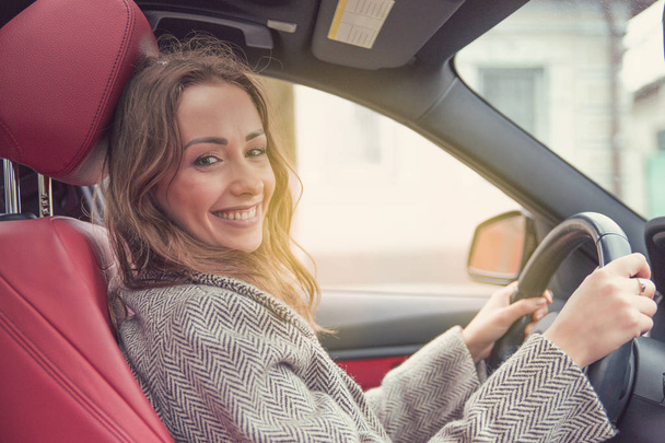 Young smiling woman driving a modern car - Foto, imagen