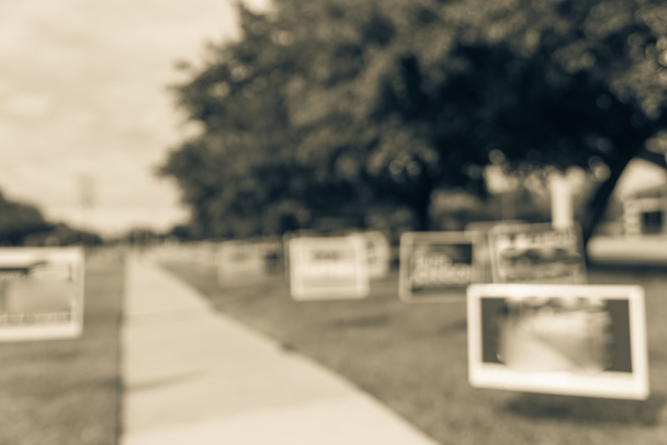 Винтажный тон размыл ряд дворовых знаков на жилой улице в день первичных выборов в округе Даллас, штат Техас, США. Знаки приветствия досрочным избирателям, плакаты политических партий в поддержку концепции промежуточных выборов
 - Фото, изображение