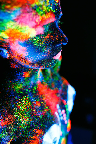 Kavram. Dj destesini boyayan bir kızın cesedinin üzerinde. Uv renklerde boyanmış yarı çıplak kız. - Fotoğraf, Görsel