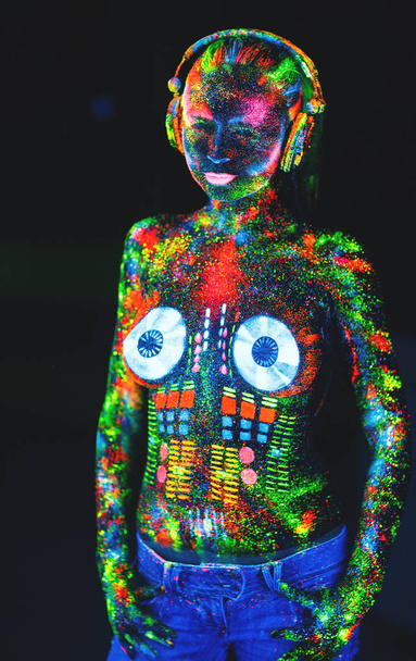 Concept. On the body of a girl painted DJ deck. Half-naked girl painted in UV colors. - Photo, Image
