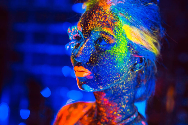 Portrait of a girl painted in fluorescent powder. - Foto, Imagem