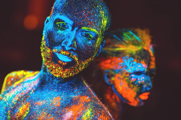 Portrait of a pair of lovers painted in fluorescent powder. - Photo, Image