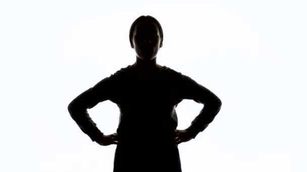 Silhouet van een jonge vrouw met handen op de heupen - Video
