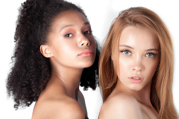 Caucasian and african teen girls close-up. Skin care and makeup. Mixed race beauty portrait - Zdjęcie, obraz