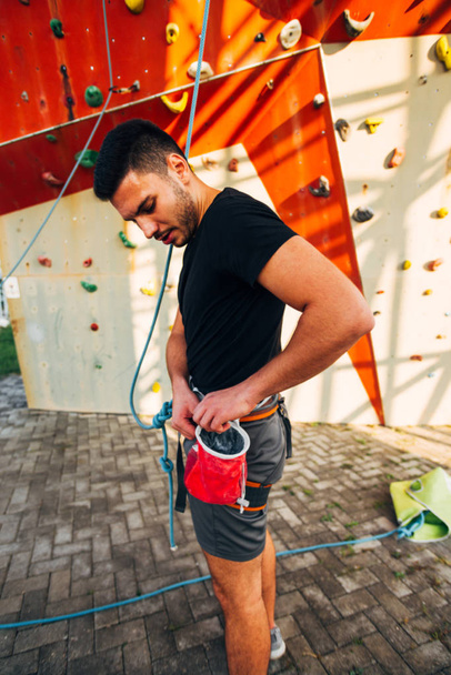 Giovane arrampicatore con cintura di imbracatura prepararsi per escursioni su grande parete - Foto, immagini