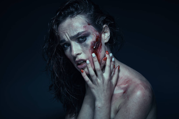 Beautiful girl with a scar on her face in the blood - Photo, Image