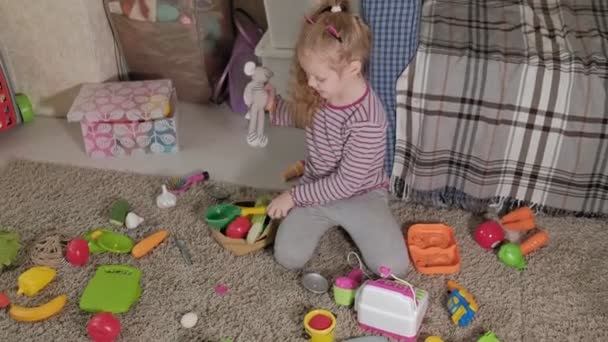 Krásné smát malé dítě, školka blondýnka hraje s barevnými hračkami, sedí na podlaze v pokoji - Záběry, video