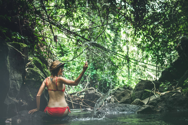 Giovane viaggiatrice nel fiume giungla. Foresta pluviale dell'isola di Bali. Concetto avventura turistica
. - Foto, immagini