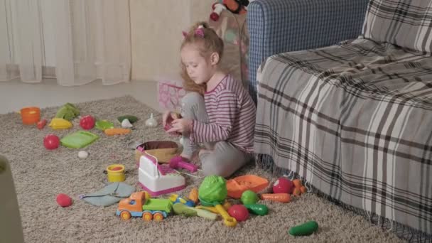 Heerlijk lachen little kid, preschool blond, spelen met kleurrijke speelgoed, zittend op de vloer in de kamer - Video