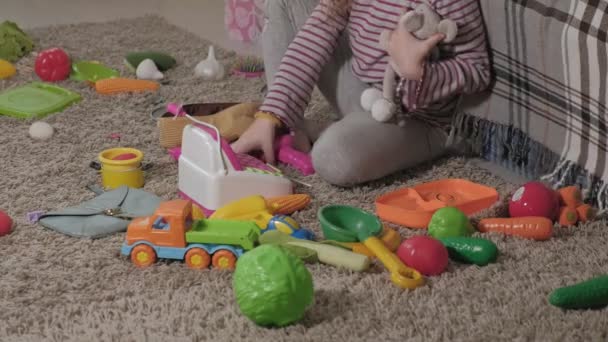 Прекрасний смішний маленький хлопчик, дошкільна блондинка, грається з барвистими іграшками, сидить на підлозі в кімнаті
 - Кадри, відео