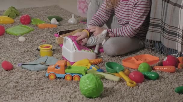 Heerlijk lachen little kid, preschool blond, spelen met kleurrijke speelgoed, zittend op de vloer in de kamer - Video