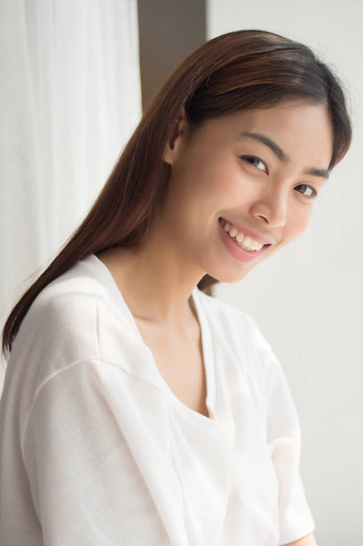 happy smiling girl; portrait of positive relaxed happy smiling asian woman smiles in indoor home environment; young adult asian persian woman or asian middle east woman model - Fotó, kép