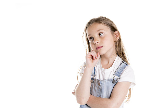 Portrait of a cute 7 years old girl Isolated over white background pensive - Photo, Image