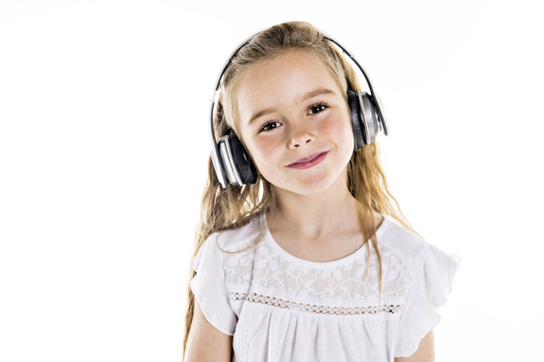 Portrait of a cute 7 years old girl Isolated over white background with headphone - Fotografie, Obrázek